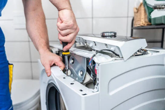 Close-up of a technician repairing the controls of a laundry appliance