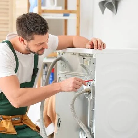 Technician working on the rear connections of a washing machine